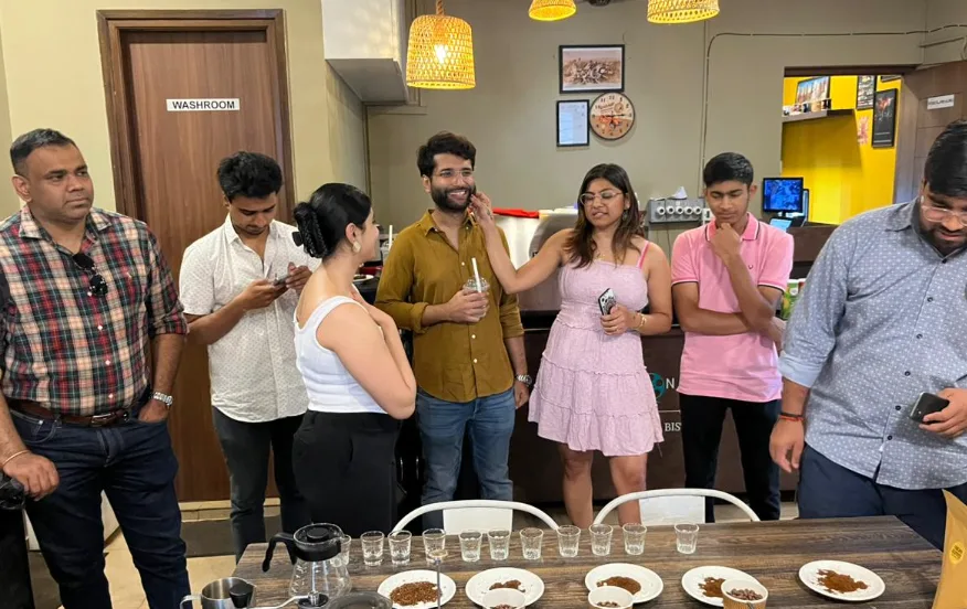 Guests gathered around a coffee tasting table inside Story Coffee House.