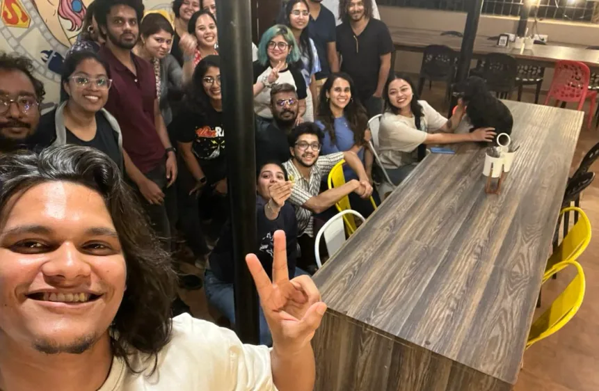 A group of friends taking a photo together around a café table.