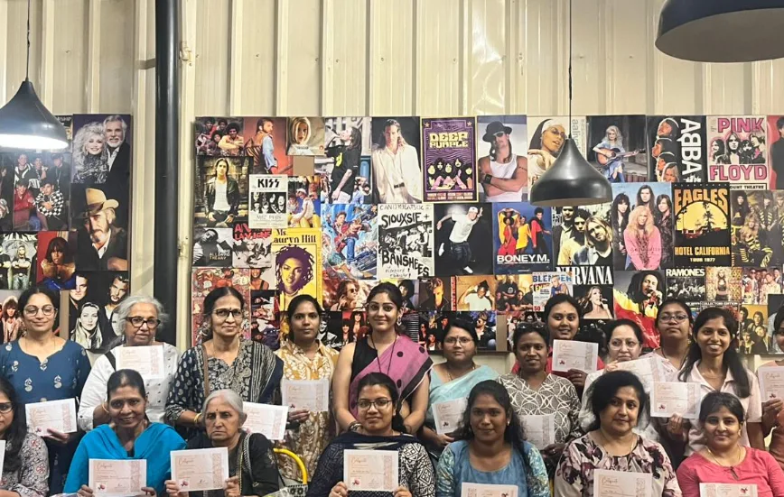Guests at a community event in front of the café music wall.